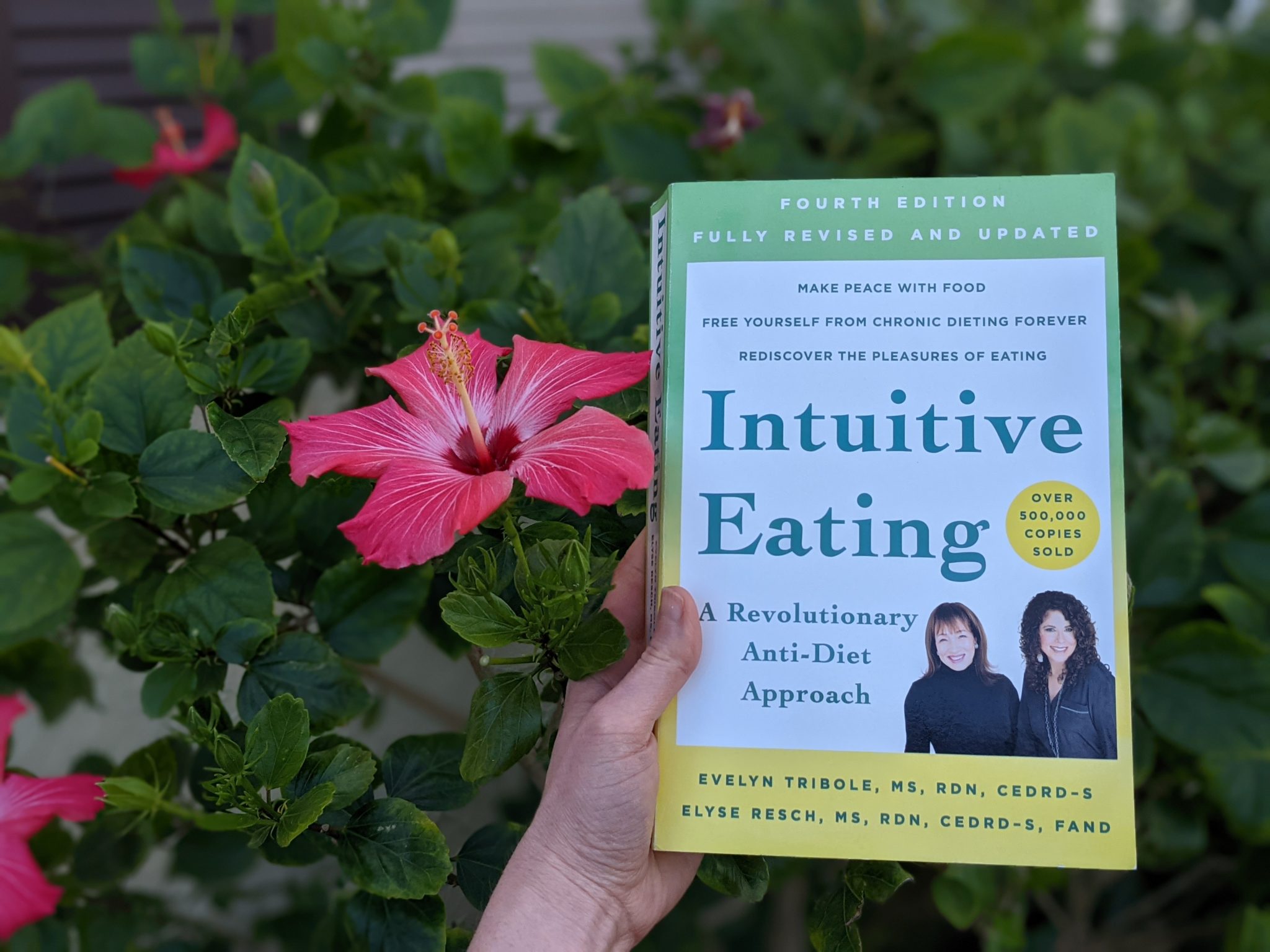 The best books about food and faith Erin holding her pick for the best intuitive eating books Intuitive Eating: A Revolutionary Anti-Diet Approach