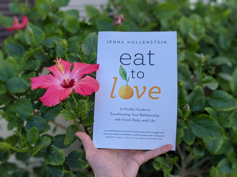 The best books about food and faith Erin holding her pick for the best intuitive eating books Eat to Love by Jenna Hollenstein